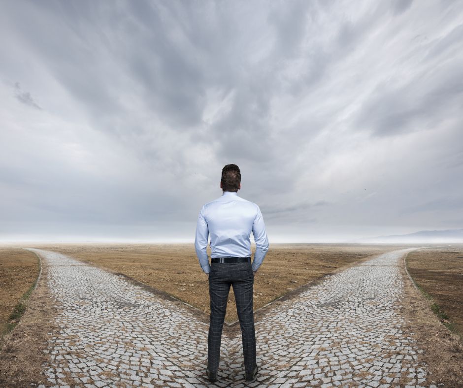 man looking at two paths discerning which to take